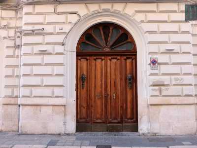 Foto 18. Proseguiamo per via Cairoli, dove al civico 141  si trova l�ultima tappa del nostro viaggio: un bell�edificio il cui portone a quattro ante � inserito in una cornice doppia con una raggiera a sette spicchi di vetro colorato (foto di Antonio Caradonna]